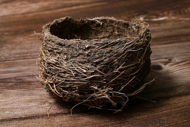 Настоящее птичье гнездо пустое, изолированное на деревянном столе.