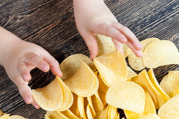 Real crispy and salty potato chips ready to eat, close up of unhealthy food products