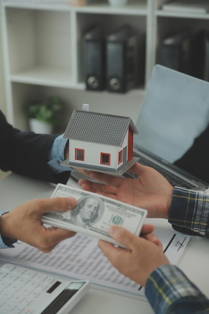 Foto l'agente immobiliare e il cliente firmano un contratto per acquistare un'assicurazione sulla casa o prestare un immobile, affittare un'assicurazione sulla casa o prestare un immobile o una proprietà