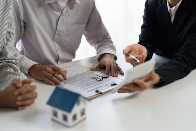Агент по недвижимости объясняет договор страхования и соглашения клиенту перед подписанием договора