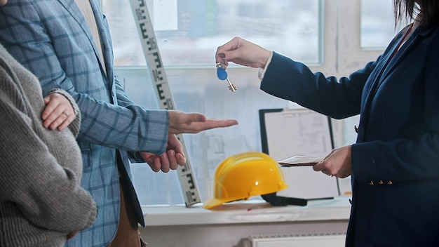 A real estate agent gives the keys to apartment to a married couple