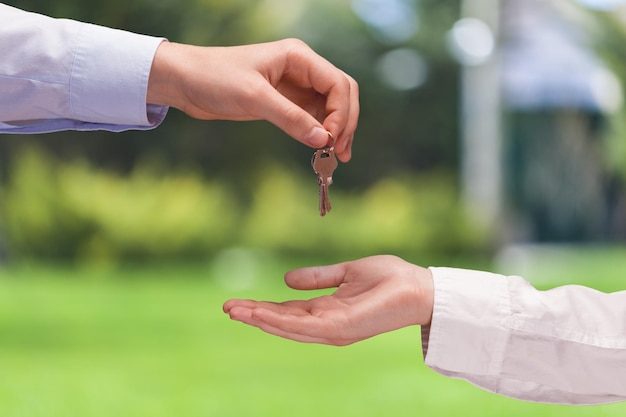 Photo real estate agent giving key to client, moving new house concept