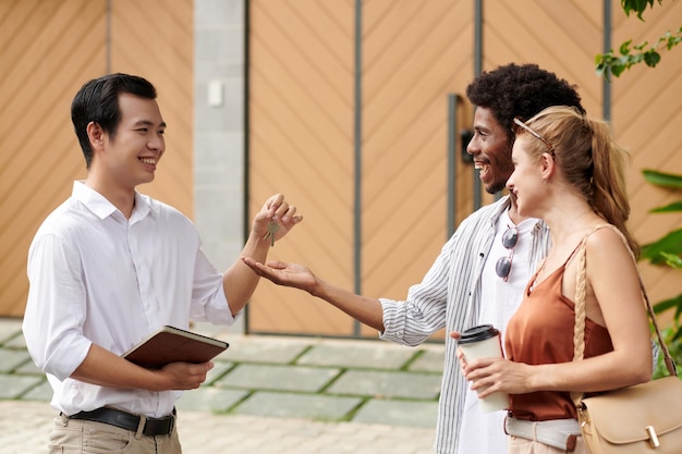 Real estate agent giving keys to new house owner