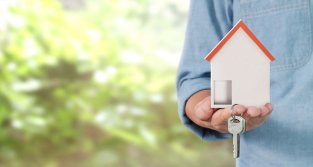 Real estate agent handing over house keys in hand