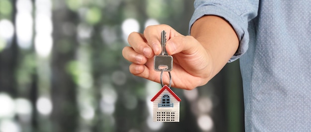 Real estate agent handing over house keys in hand