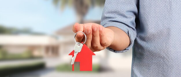 Photo real estate agent handing over house keys in hand