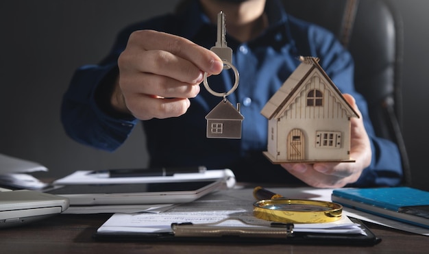 Агент по недвижимости держит ключ от дома