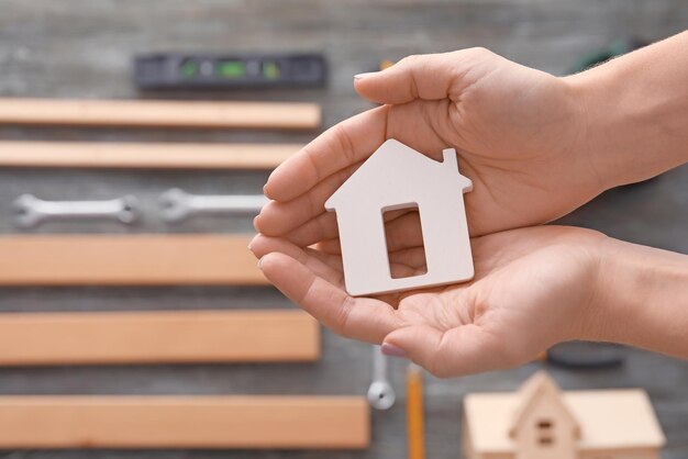 Real estate agent holding house model on blurred background