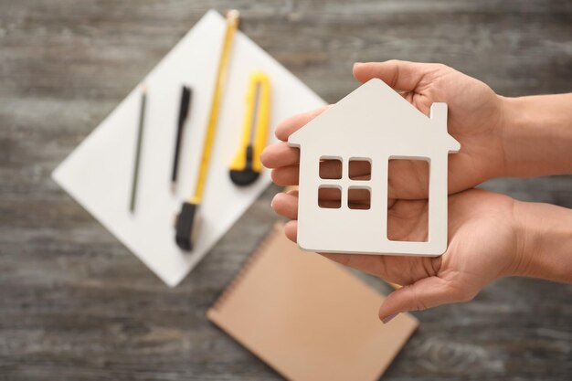 Real estate agent holding house model on blurred background