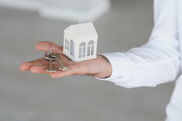 Real estate agent holding key and house model