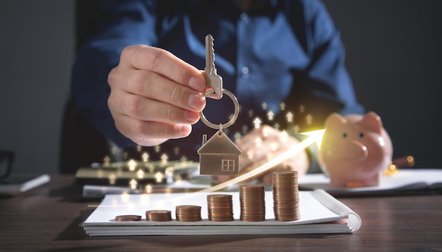 Real estate agent showing house key over stack of coins. Real Estate Graph. House market growth