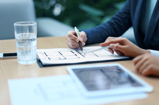 Real-estate agent showing house plans on electronic tablet