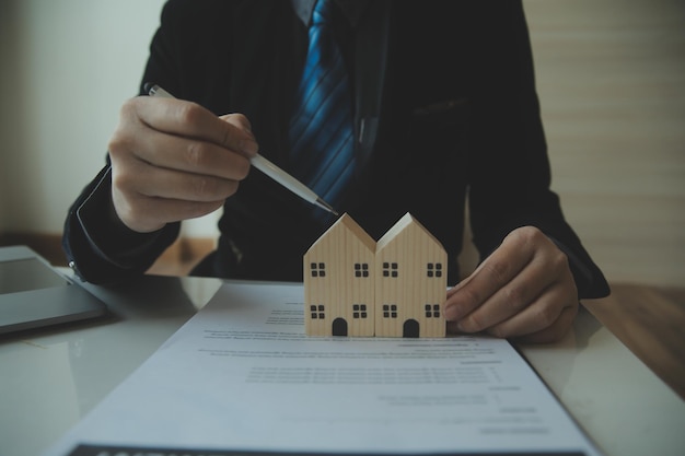 Real estate agent talked about the terms of the home purchase agreement and asked the customer to sign the documents to make the contract legally Home sales and home insurance concept