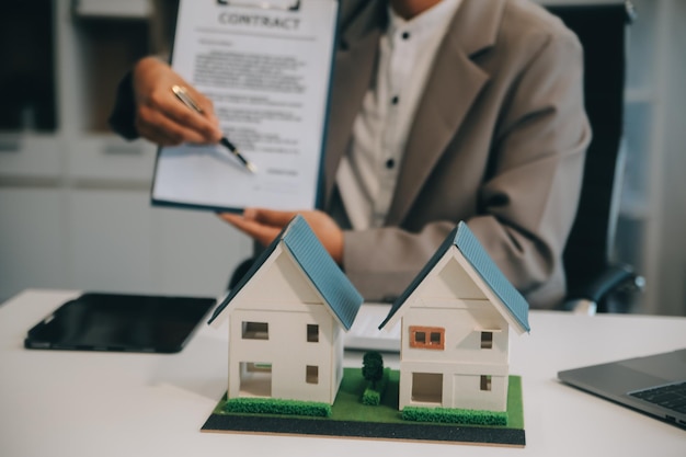 Real estate agent talked about the terms of the home purchase agreement and asked the customer to sign the documents to make the contract legally Home sales and home insurance concept