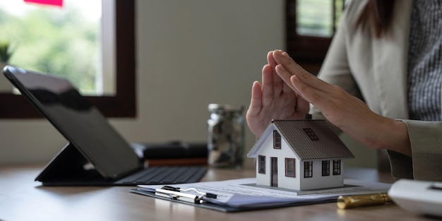 Real estate agent use their hands to protect the red roofs the concept of protecting houses using the gestures and symbols of real estate investors taking care of credit and contracts