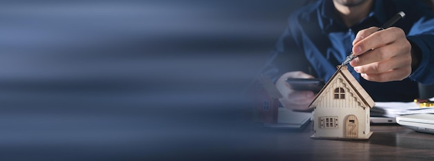 Photo real estate agent using a pen pointing to the house model