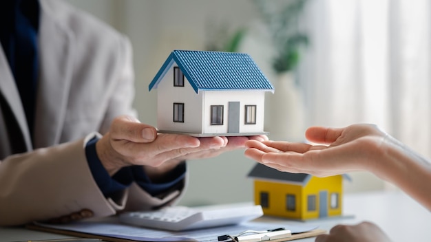 Real estate agents explain models of housing estates in projects to elaborate to clients explaining and presenting information about homes and purchasing loans Real estate trading concept