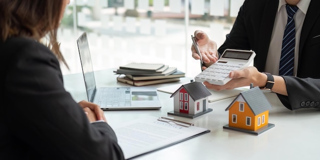 Real estate agents talk to client and offer good interest rates and calculate clients on mortgage financing to help them decide on real estate ideas with insurance