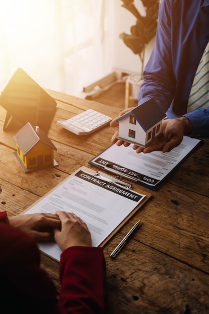 부동산 중개인 에이전트는 주택 보험에 대한 모기지론 제공 및 주택 보험에 관한 주택 모델에 대한 의사 결정 서명 보험 양식 계약을 제시하고 고객에게 상담합니다.