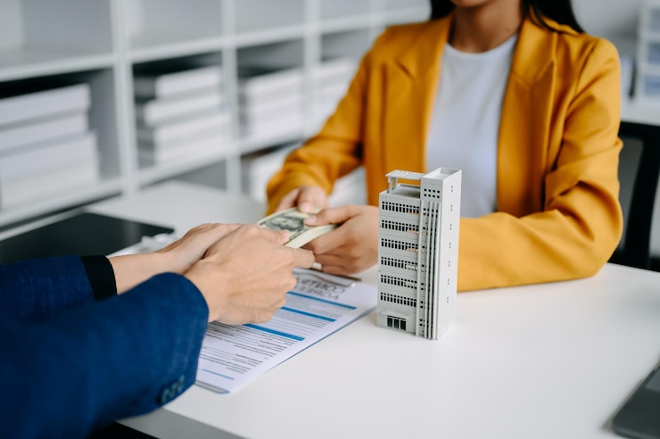 Photo real estate broker agent presenting and consult to customer to decision making sign insurance form agreement home model concerning mortgage loan offer in office