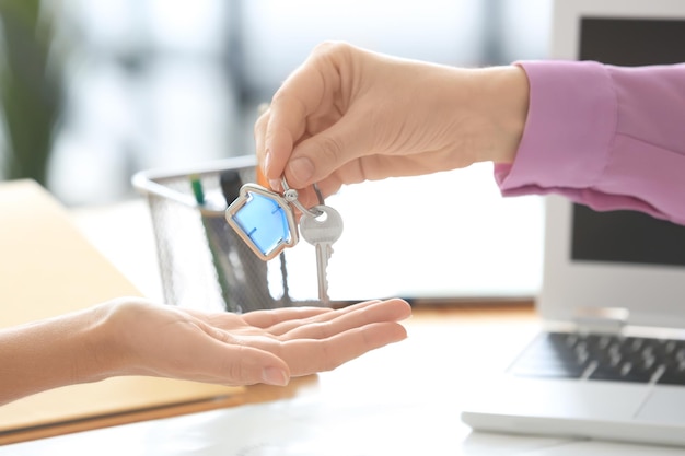 Real estate broker giving customer key from new flat