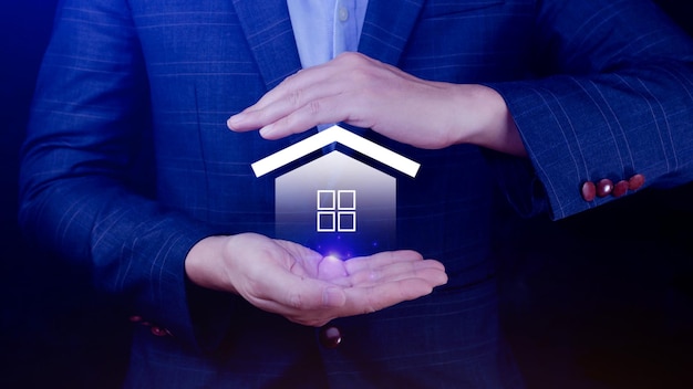 Real estate concept Businessman holding home icon Property insurance and security concept Protecting gesture and symbol house Real estate agent providing home