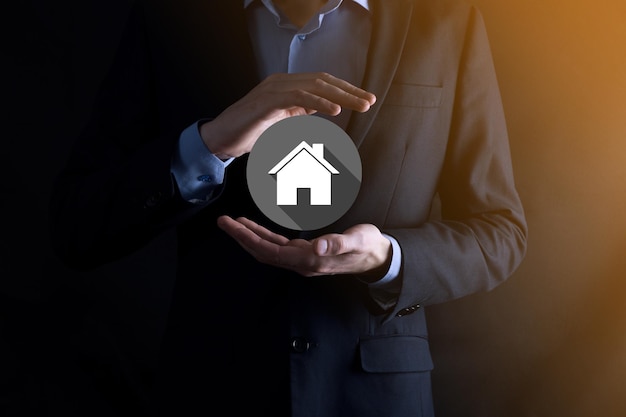 Real estate concept, businessman holding a house icon.House on Hand.Property insurance and security concept. Protecting gesture of man and symbol of house.flat icons with long shadows.