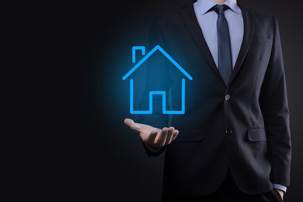 Real estate concept, businessman holding a house icon.house on\
hand.property insurance and security concept. protecting gesture of\
man and symbol of house.