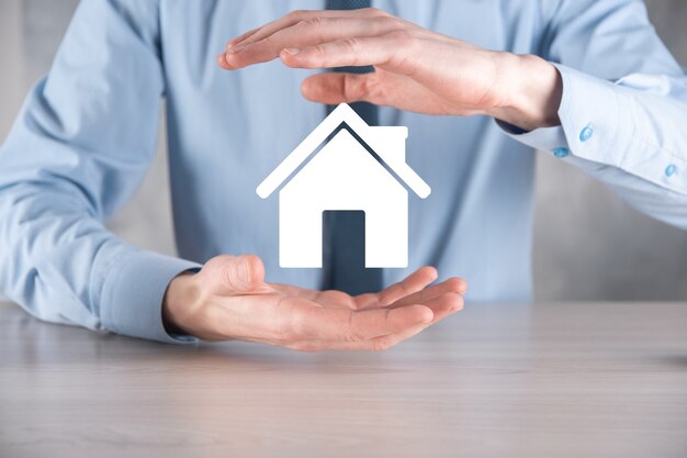 Real estate concept, businessman holding a house icon.House on Hand.Property insurance and security concept. Protecting gesture of man and symbol of house.