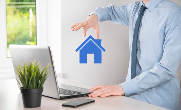 Real estate concept, businessman holding a house icon.House on Hand.Property insurance and security concept. Protecting gesture of man and symbol of house.