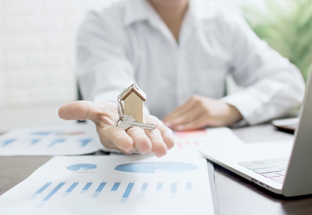 Концепция недвижимости, холдинг дома агента, банкир, показывая модель на графике жениха