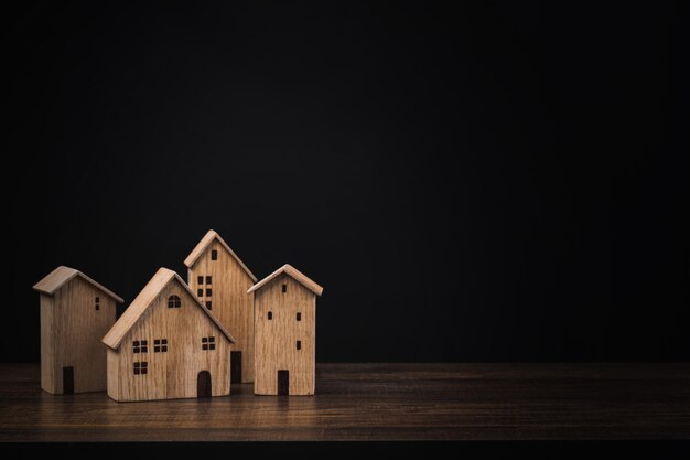 real estate concept small wooden house or home on table with black background