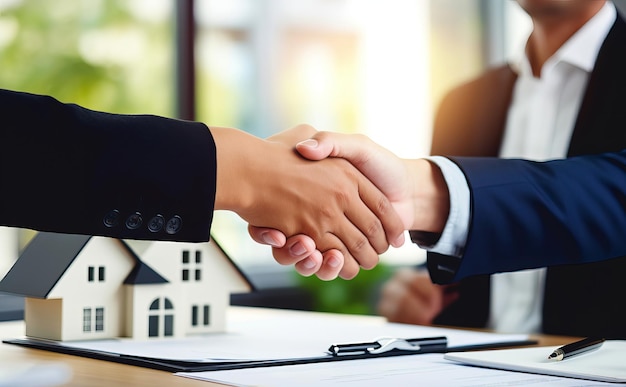 Концепция сделки с недвижимостью рукопожатие между бизнесменами перед моделью дома