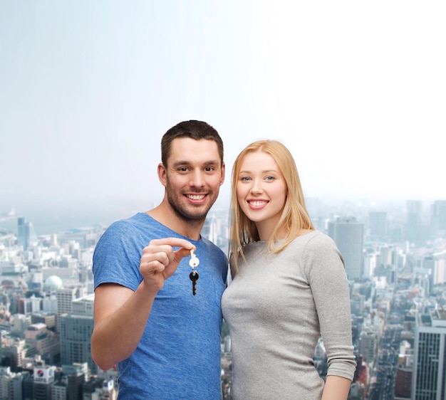 real estate, family and couple concept - smiling couple holding keys