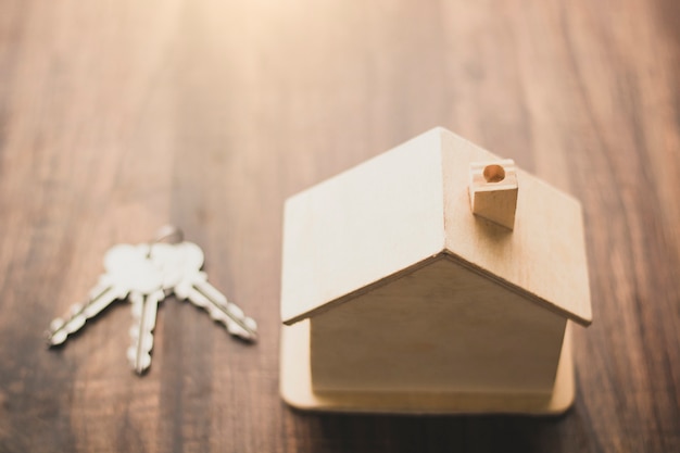 Real estate home and residential business concept, house model and keys place on wood table