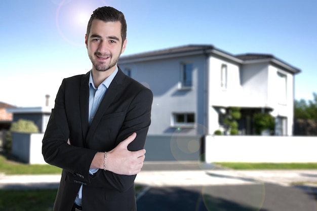 Photo real estate man front of new house to sale rent portrait arms crossed