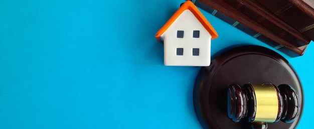 Real estate model of house with judge gavel closeup