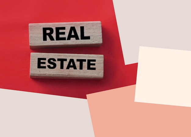 Real estate text on wooden blocks on red Rent buy property concept