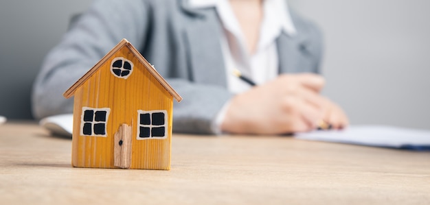 Real estate, woman working in document with house model