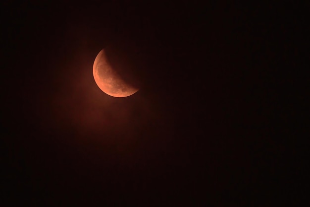 Real full blood moon half moon in black sky with cloud