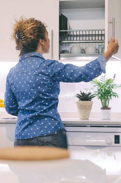 Real home life concept lifestyle Vrouw achteruitzicht met behulp van keuken huis magazijn om te koken en bereiden lunch of diner voor de familie Een vrouwelijke mensen bezig in de keuken voor de bereiding van eten