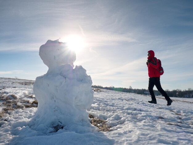 写真 冬の風景に立つ真の氷の雪人温泉の太陽と地平線で歩く人々