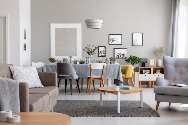 Real photo of a modern living room interior with a dining table and graphics on a wall