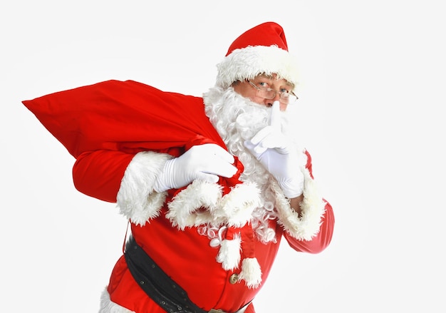 Real santa claus carrying big bag full of gifts isolated on white background