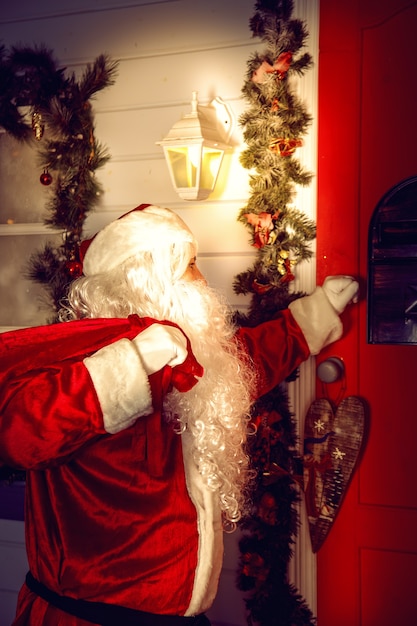 The real Santa Claus. Santa knocks on the door. Christmas night