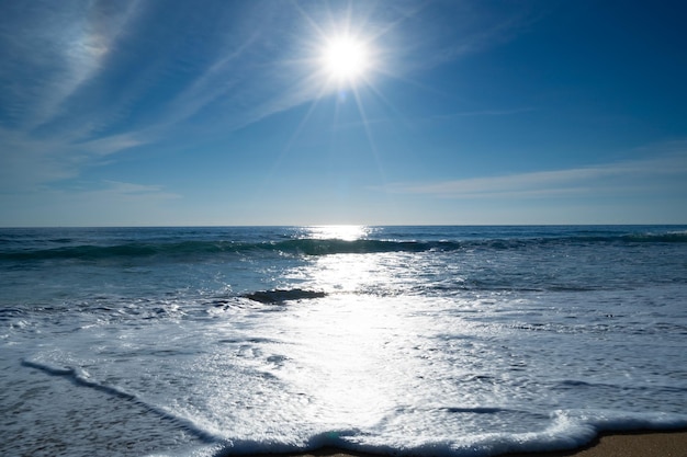 Vista realistica della natura del sole giornata di sole estivo l'orizzonte dell'oceano marino con un bel bagliore di luce solare sul mare sfondo estivo soleggiato