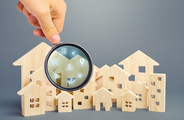 Realtor examines houses through a magnifying glass