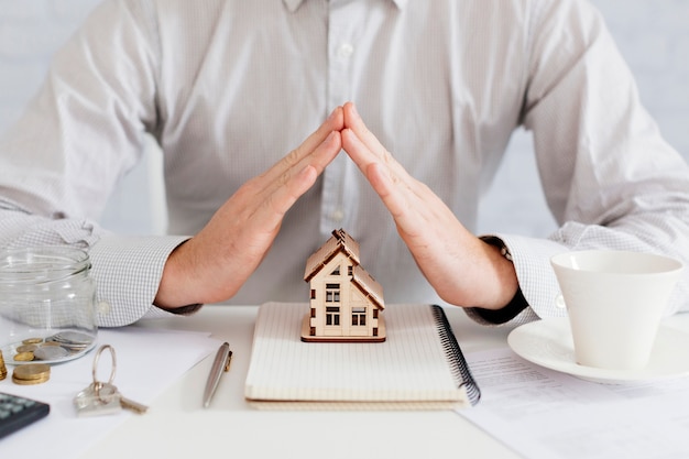 Realtor gesturing at house