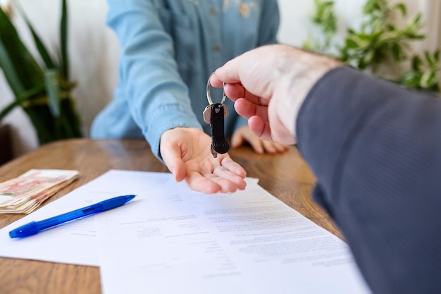 Realtor gives the keys to the new owner. Close-up of hands. Indoor. Rental and purchase.