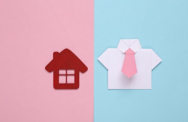 Realtor camicia origami con cravatta e casa fuga su sfondo blu rosa pastello